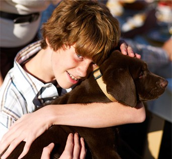 A child hugging a dog